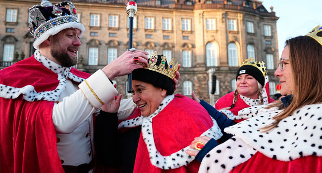 Pedesitrans dress as royals at Christiansborg Palace Square before the proclamation of abdication of Denmark’s Queen Margrethe II, in Copenhagen, on January 14, 2024. Denmark turns a page in its history on January 14 when Queen Margrethe abdicates and her son becomes King Frederik X, with more than 100,000 Danes expected to turn out for the unprecedented event. (Photo by Mads Claus Rasmussen / Ritzau Scanpix / AFP)